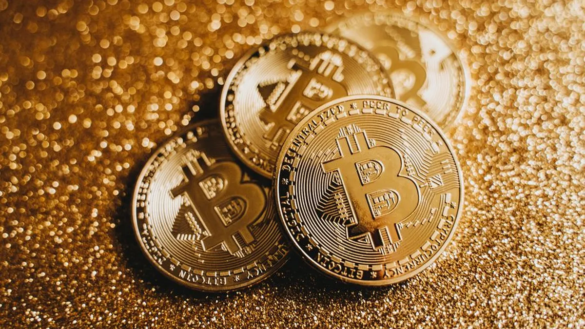 Close-up of golden Bitcoin coins on a sparkling, glitter-covered surface highlighting cryptocurrency wealth.